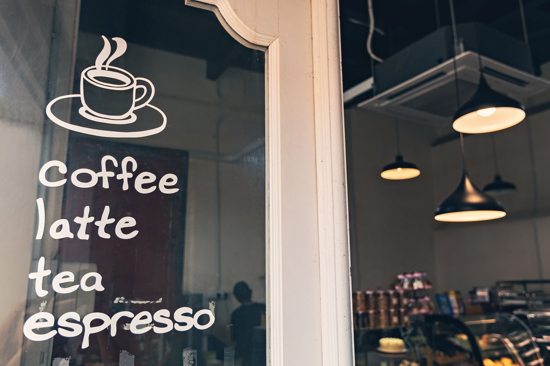 Cozy coffe shop entrance door with coffee menu written on the glass